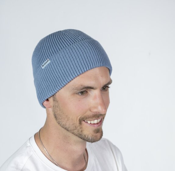 Mann mit hellblauer Ski amadé Mütze und weißem Shirt vor hellem Hintergrund | © Ski amadé GmbH / Lorenz Masser