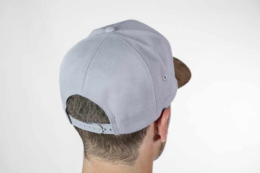 Schräger Rückblick auf graues Baseballcap mit verstellbarem Snapback-Verschluss auf dem Kopf eines Mannes | © Ski amadé GmbH / Lorenz Masser
