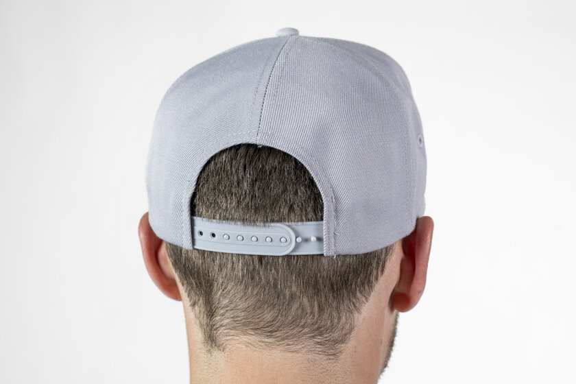 Rückansicht eines grauen Baseballcaps mit verstellbarem Snapback-Verschluss auf dem Kopf eines Mannes | © Ski amadé GmbH / Lorenz Masser