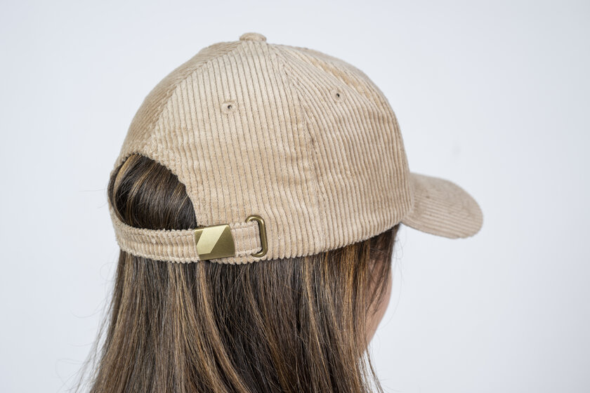 Rückseite eines beigen Cord-Baseballcaps mit verstellbarem Metallverschluss auf dem Kopf eines Mädchens | © Ski amadé GmbH / Lorenz Masser