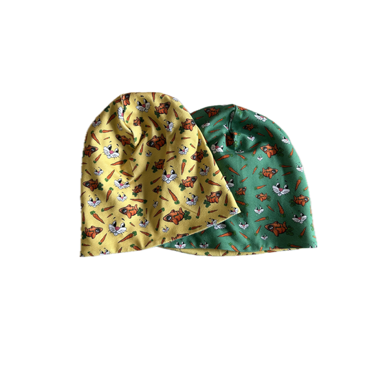 Kindermütze auf Glasmodellkopf, bedruckt mit Hasengesichtern, Karotten und orangen Hasenfiguren, Lederlabel seitlich | © Planai-Hochwurzen-Bahnen GmbH