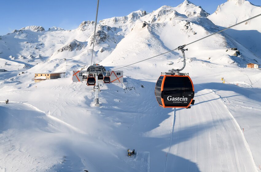 Modern gondola lift travels above snow-covered slopes in Gastein ski area with alpine mountain panorama in sunshine | © Gasteiner Bergbahnen AG